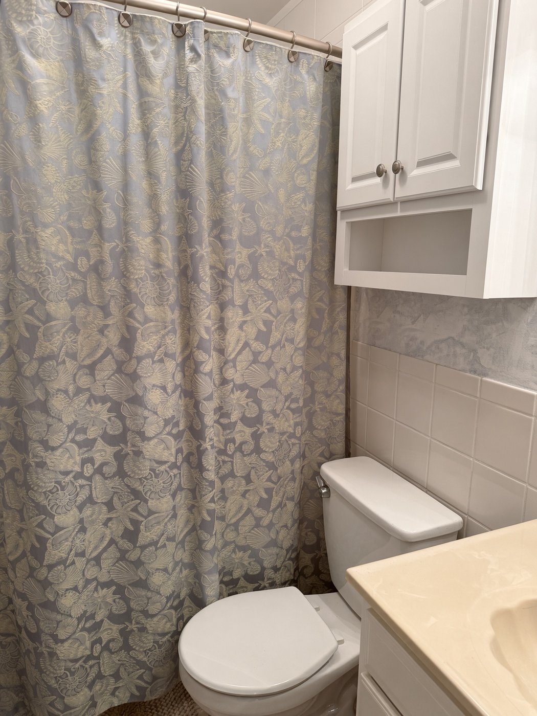 The full bathroom at Lucky Landing with tub-shower, tile, and vanity storage