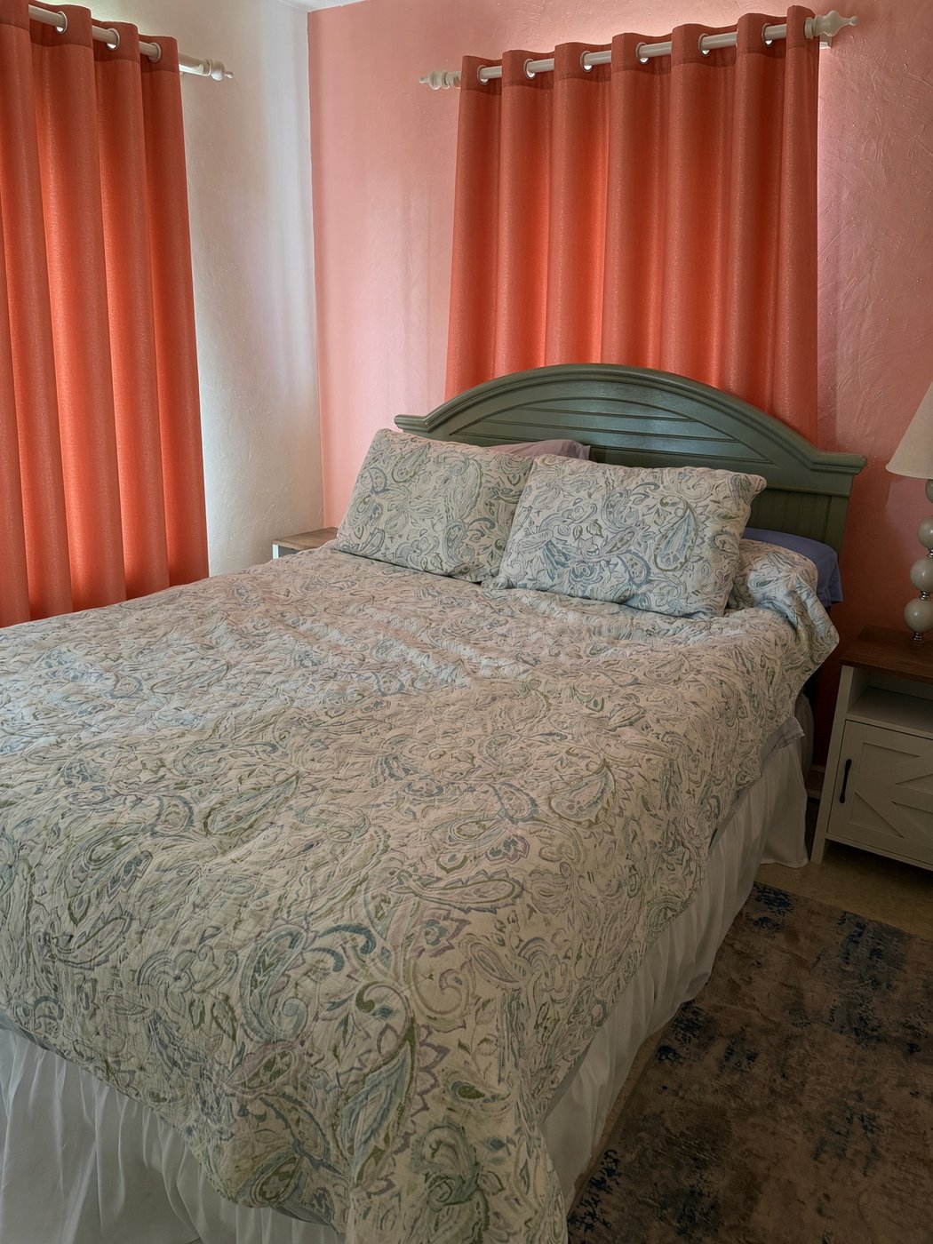 Queen bedroom at Lucky Landing with coastal bedding and a green headboard