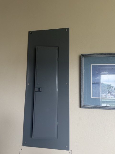 The grey breaker panel on the dining room wall near the deck door