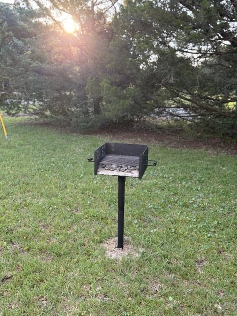 The post-mounted charcoal grill in the yard at Lucky Landing