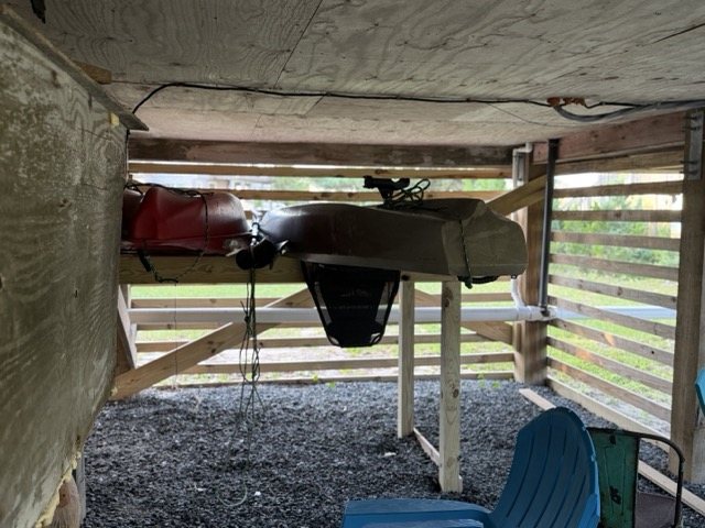 The kayaks stored on their rack under the house at Lucky Landing
