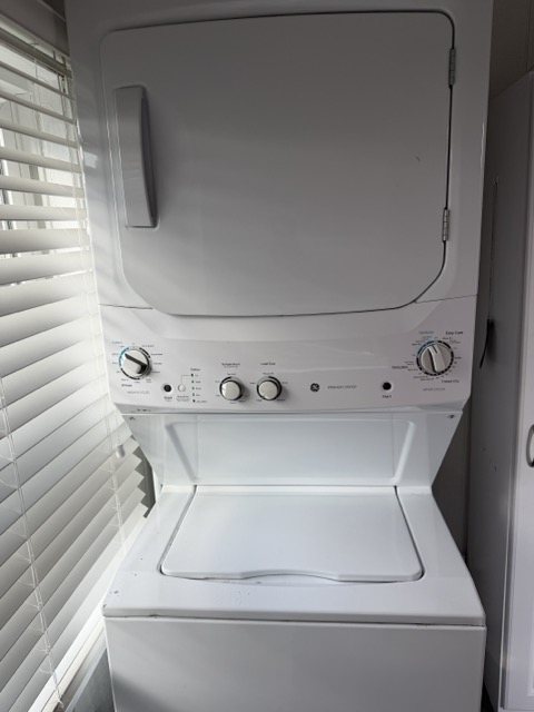 The stacked GE washer and dryer in the laundry closet